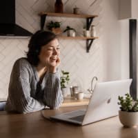 Woman smilling looking at her laptop.